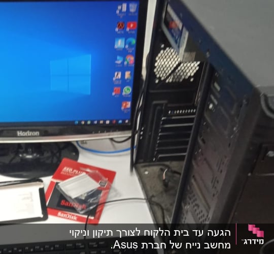 מחשב פתוח עם מסך, מקלדת ואריזת כונן SSD